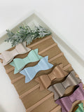 Set of 10 faux leather baby bows.